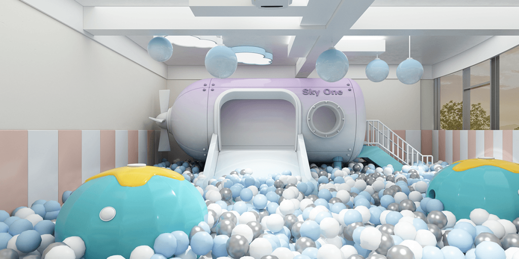 Bright play area with a large purple slide, colorful ball pit, and floating decorative balls.