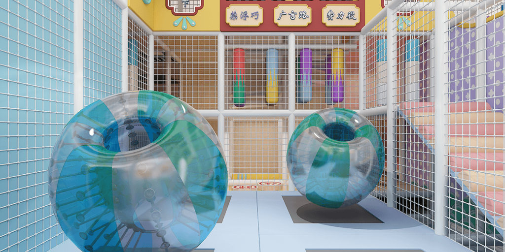 Play area with two colorful inflatable zorbing balls, surrounded by protective mesh and vibrant tube-shaped structures.
