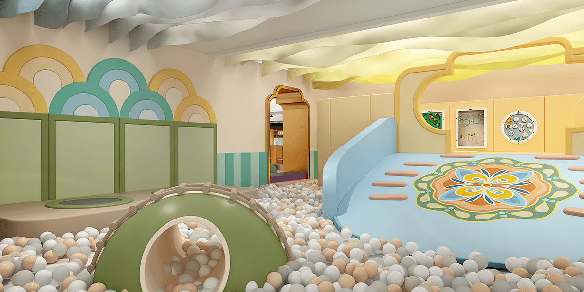 Colorful play area with a ball pit, a soft slide, curved walls in pastel colors, and interactive play panels.
